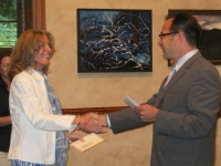 Park Avenue Club Executive Director Michael Frodella presents Marcia Gloster Ammeen an award for her painting, Namibia Dunes